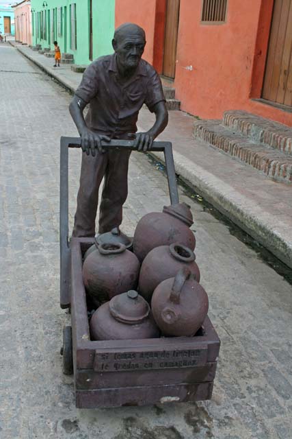 Statue of a man wheeling a barrow full of <em>tinajones</em> in <em>Plaza del Carmen.</em>