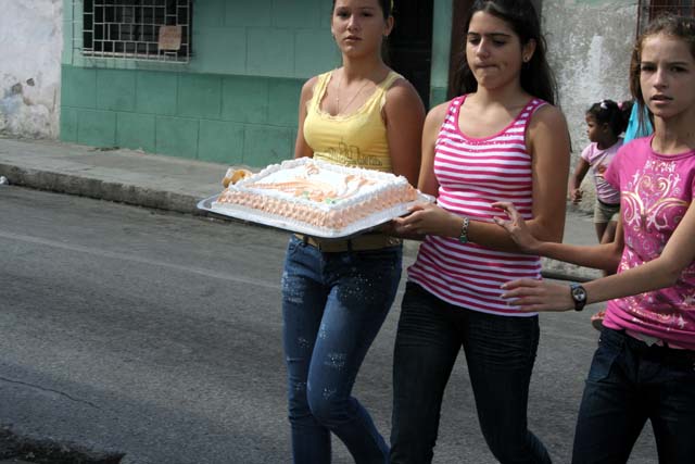 Three girls with what looks like an important cake.