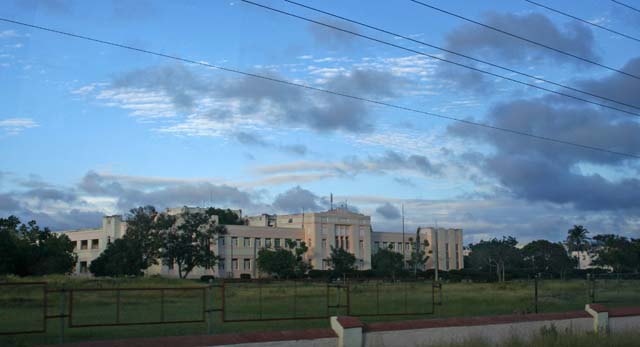 An imposing building (school? factory?) under a dramatic sky.