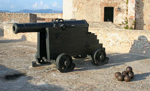 One of the cannons with its cannonballs.