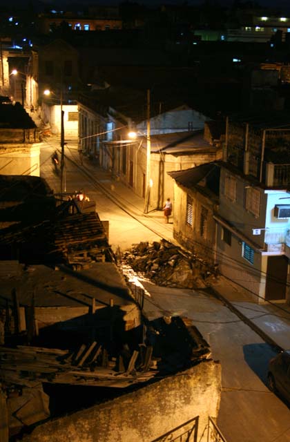 Looking down at the street at night. Note the pile of rubble.