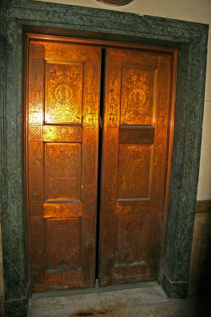 The ornate, but rather worn, lift doors.