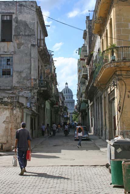 Contrast: a crumbling street with <em>El Capitolio</em> in the distance.