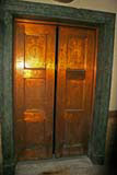 The ornate, but rather worn, lift doors.