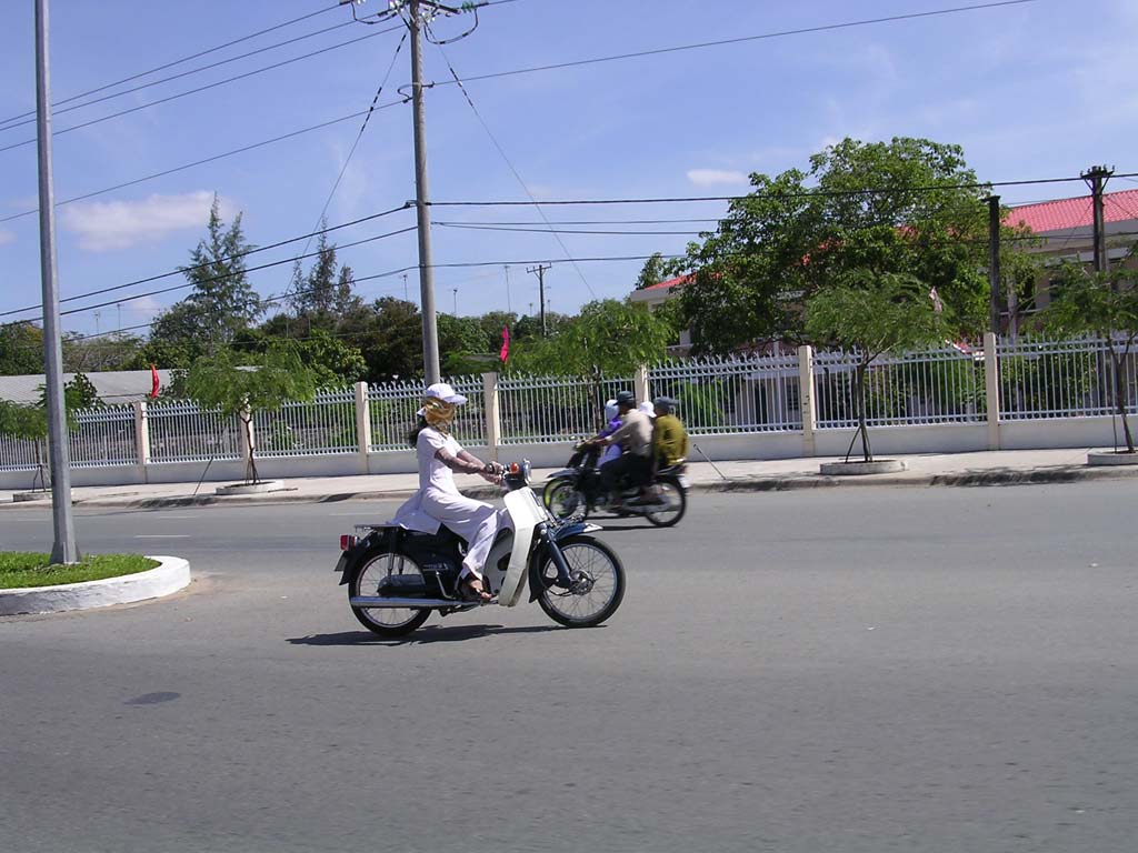 Schoolgirl in the standard white dress on a moto