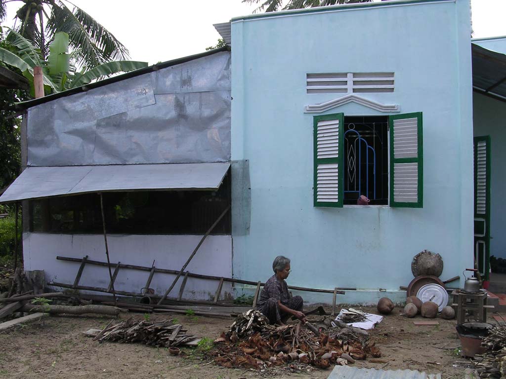 Hung's mother chopping wood next door