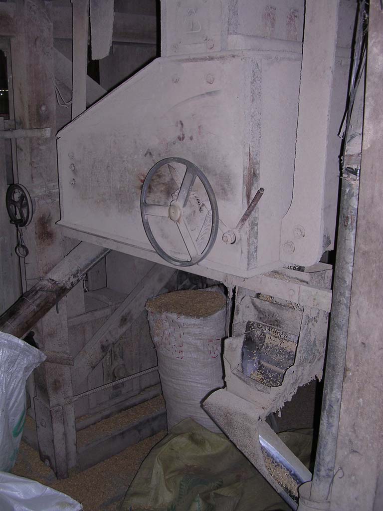 A bag of something (husks? raw rice?) and some rice going down a chute