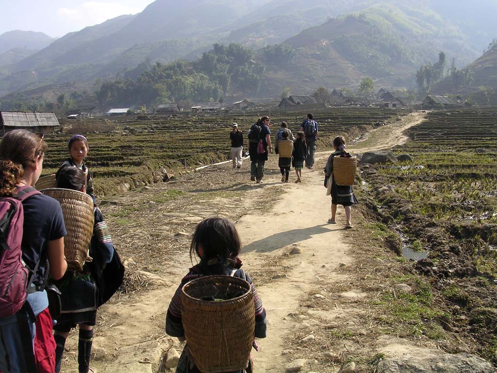 A group of friendly Black H'mong girls - with backpacks - with members of our group