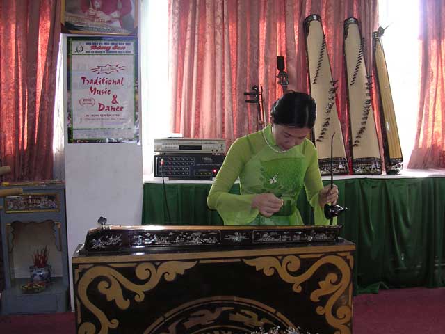 Ngo Tuyet Mai demonstrates the dan bau in the music room of the Reunification Palace, Saigon
