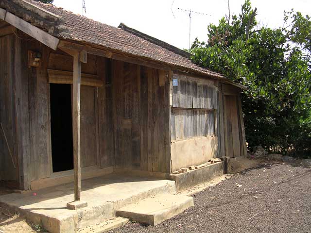 The house and porch, with coffee beans drying in the yard