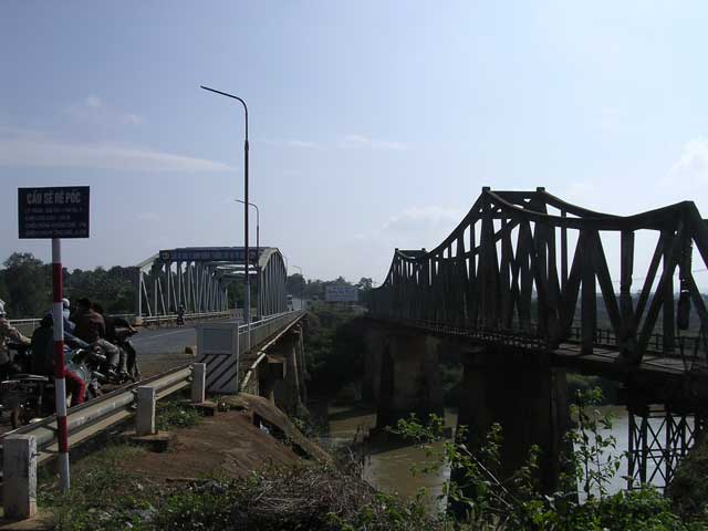 Crossing the Srepok river again by a new bridge. The old one still retains some war damage (far R of photo)