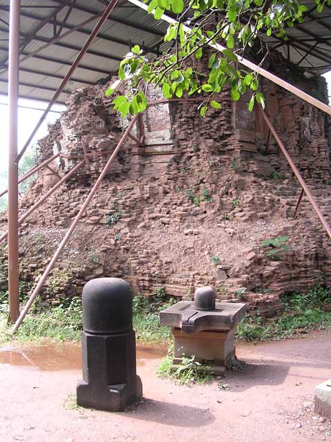 Linga and yoni in front of a monument strapped together against final collapse