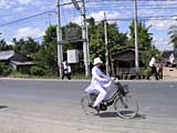 Typical Vietnamese schoolgirl on a bike in the standard white dress