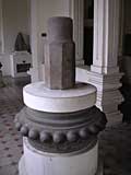 A linga on a circular base decorated with breasts