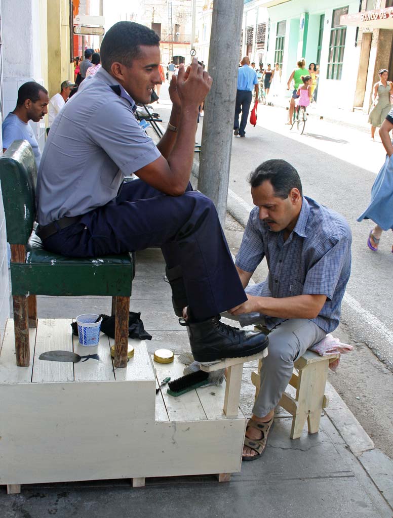 A policeman having his shoes shined.