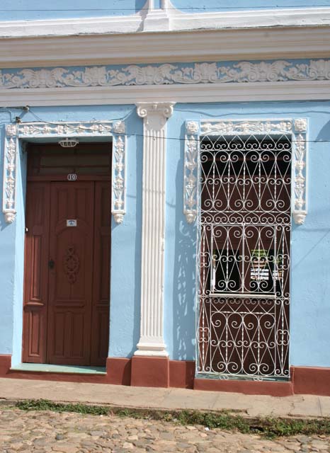 This one, with its elaborate window grille, is a <em>casa particular</em> - see the little sign on the door.